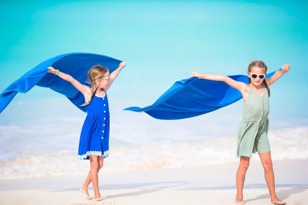 Kleine Mädchen haben Spaß beim Laufen mit Handtuch und genießen ihren Urlaub am tropischen Strand mit weißem Sand und türkisfarbenem Meerwasser — Stockfoto