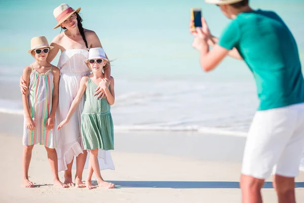 Hombre tomando una foto de su familia en la playa — Foto de Stock