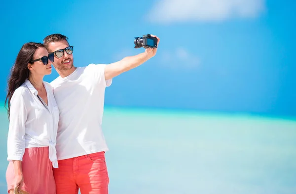 Pareja selfie tomando fotos en la playa. Turistas personas que toman fotos de viaje en vacaciones de verano . — Foto de Stock