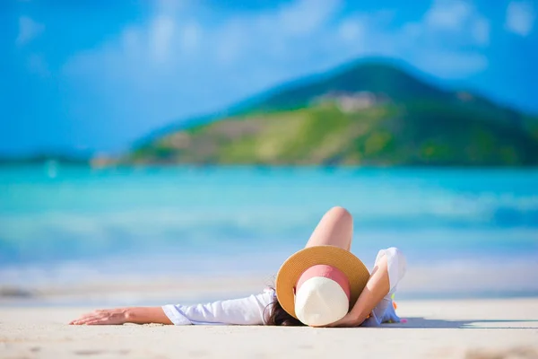 Jovem mulher desfrutando do sol banhos de sol pelo perfeito oceano azul-turquesa . — Fotografia de Stock