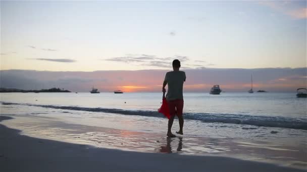 Menina e feliz pai se divertindo ao pôr do sol durante as férias na praia — Vídeo de Stock