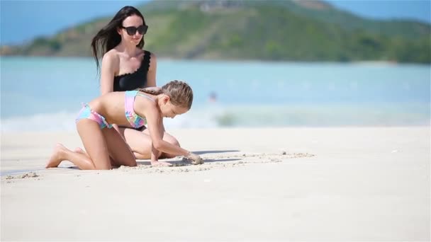 Mère et sa petite fille profitent de vacances à la plage dans les Caraïbes. Famille jouant avec le sable sur la plage tropicale — Video