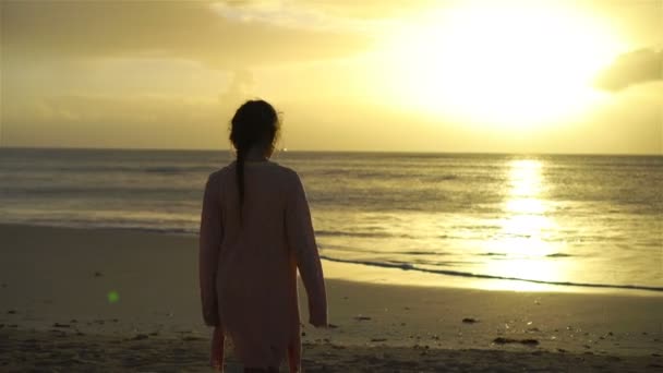 Entzückend glückliches kleines Mädchen am weißen Strand bei Sonnenuntergang — Stockvideo