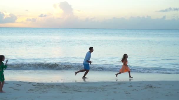 Familie plezier op het strand bij zonsondergang. Slow Motion — Stockvideo