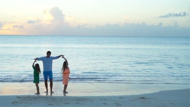 Famille s'amuser sur la plage au coucher du soleil. MOTION DE LENT — Video