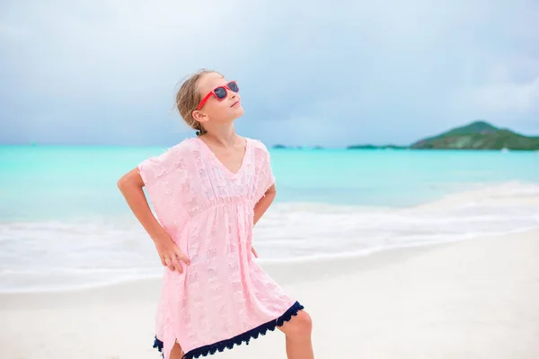 Красива маленька дівчинка в одязі на пляжі розважається. Смішна дівчина насолоджується літніми канікулами . — стокове фото