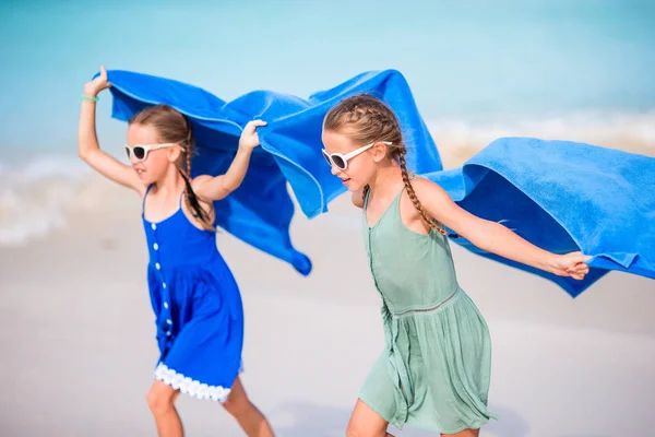 Söta små flickor som har roligt springa med handduk och njuta av semester på tropisk strand med vit sand och turkos havsvatten — Stockfoto