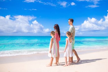 Mutlu aile çocuklarla sahilde yürümek