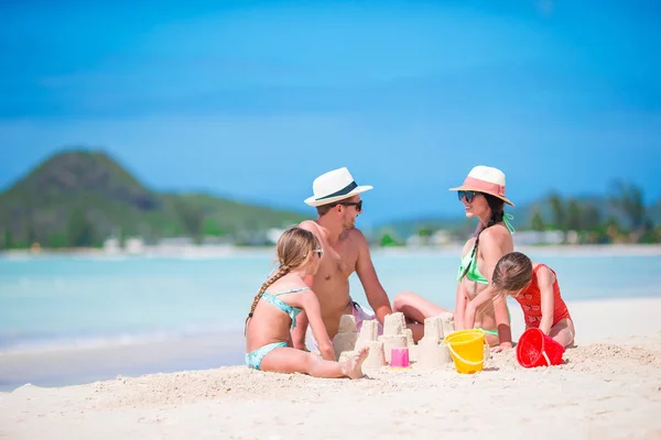 Família fazendo castelo de areia na praia branca tropical — Fotografia de Stock