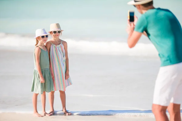 Hombre tomando una foto de sus hijos en la playa — Foto de Stock