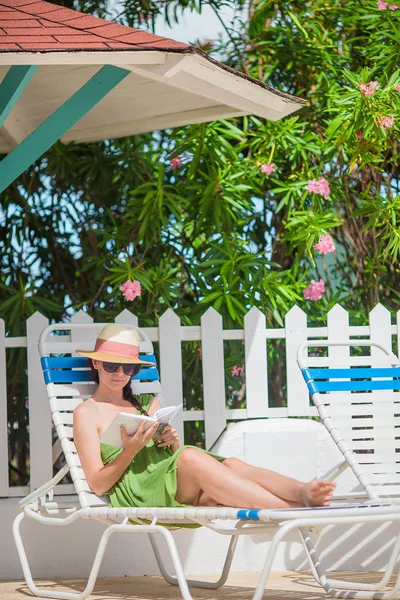 Junge Frau liest Buch in der Nähe von Schwimmbad — Stockfoto