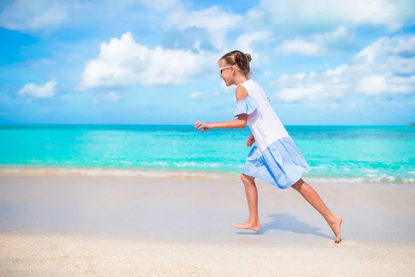 Šťastná holčička, běh a šplouchání v mělké vodě na pláži, s hodně zábavy na letní prázdniny — Stock fotografie