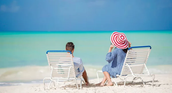 Dva šťastní lidé baví na pláži, sedět na pohodlné lehátko — Stock fotografie