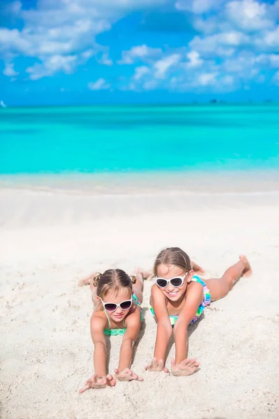 Imádnivaló kis nővérek során a nyári nyaralás feküdt a tengerparton meleg homok — Stock Fotó