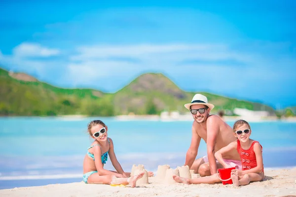 Familj gör sand slott på tropisk vit strand. — Stockfoto