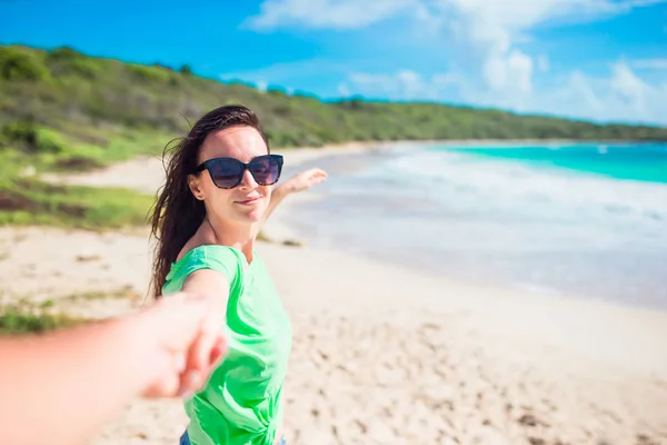 Följ mig POV - Par som älskar att ha kul. Pojkvän efter flickvän hålla händerna på vit vild strand skrattar och ler njuter av aktiv utomhus livsstil — Stockfoto