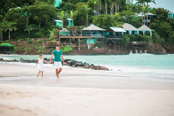 Ευτυχισμένος πατέρας και η αξιολάτρευτη μικρή κόρη στην τροπική παραλία περπάτημα μαζί — Φωτογραφία Αρχείου