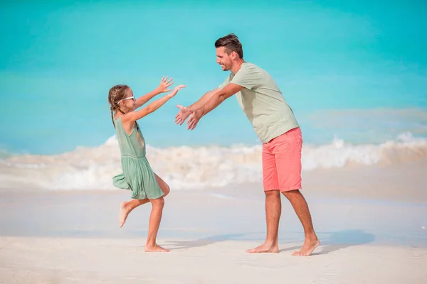 Šťastný otec a jeho rozkošné malé dítě na tropické pláži baví — Stock fotografie