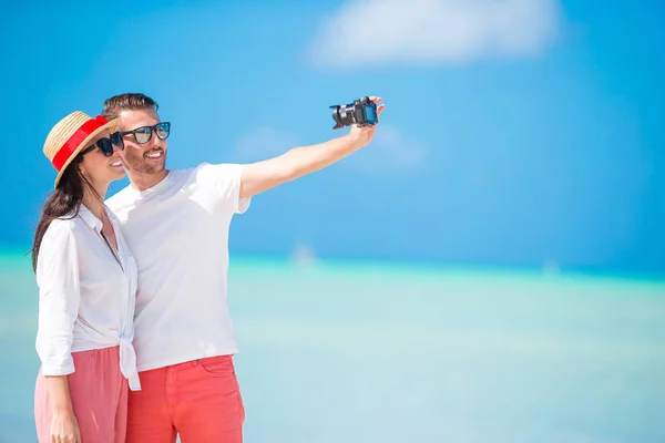 自拍夫妇在海滩上拍照。游客们在暑假里拍照旅行照片. — 图库照片