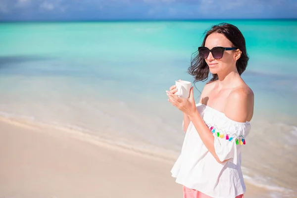 Jonge vrouw met warme koffie genieten van uitzicht op het strand. — Stockfoto