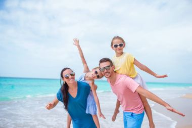 Tropik bir sahil tatilinde mutlu ve güzel bir aile.