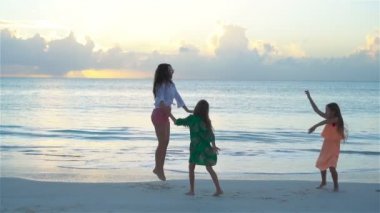 Anne ve çocuklar plaj tatil tropikal yaz zevk. Aile beyaz kumsalda dans. Ağır çekim