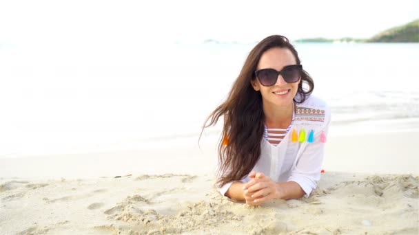 Mooie jongedame plezier op tropische kust. Gelukkig meisje liggen op het witte zand tropisch strand. — Stockvideo