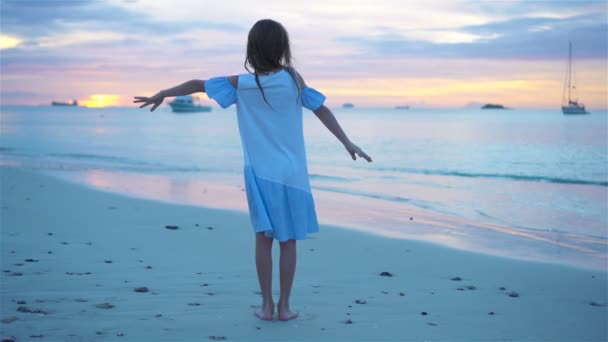 Sihouette voor meisje dansen op het strand bij zonsondergang. — Stockvideo