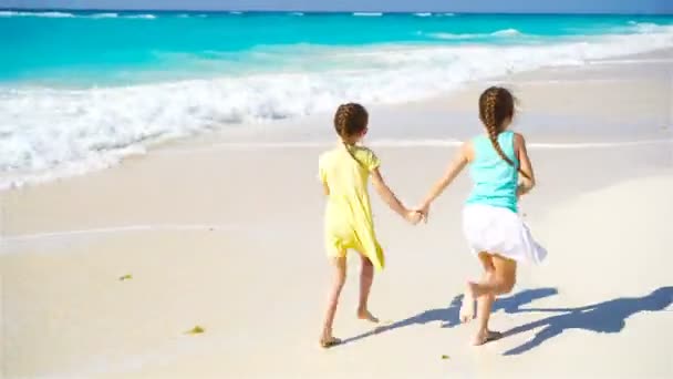 Αξιολάτρευτο μικρό κορίτσια κατά τη διάρκεια της καλοκαιρινές διακοπές έχοντας διασκέδαση στην παραλία με λευκή — Αρχείο Βίντεο