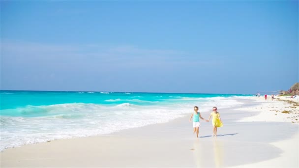 Adorables petites filles ont beaucoup de plaisir sur la plage. Deux beaux enfants courent et éclaboussent en eau peu profonde — Video