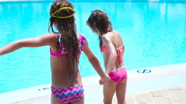Roztomilé holčičky hrají v venkovním bazénu — Stock video
