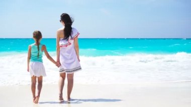 Aile Eğlence beyaz kum üzerinde. Anne ve güneşli bir günde kumlu plajda oynayan sevimli çocuk gülümseyen