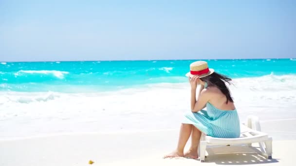 Fiatal gyönyörű nő a fehér homokos trópusi strandon. Vissza kilátás kaukázusi lány kalap háttér a tenger — Stock videók