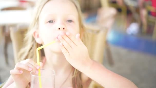 Portret van een schattig klein meisje zittend door eettafel anddrinking vers sap — Stockvideo