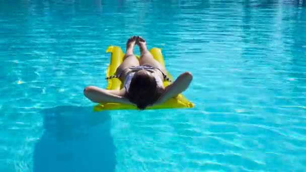 Jovem relaxante com colchão de ar na piscina ao ar livre — Vídeo de Stock