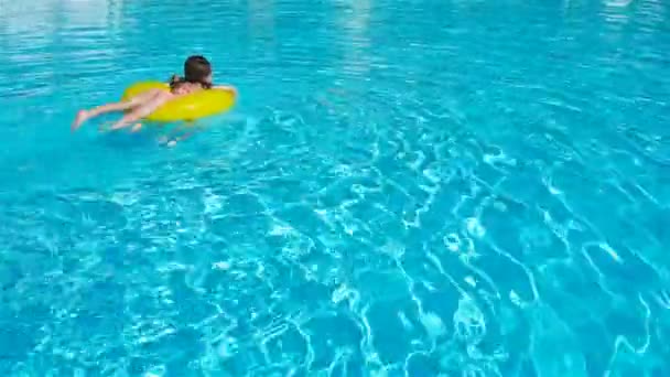 As meninas pequenas têm muito divertimento com círculo de borracha inflável na piscina — Vídeo de Stock