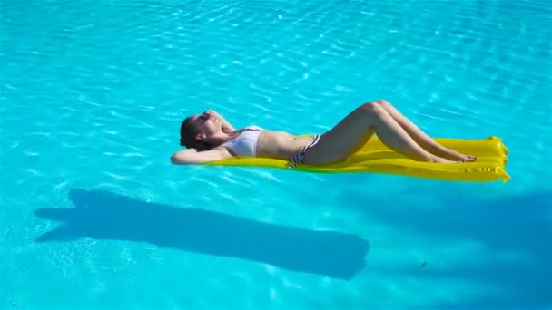 Mujer joven relajándose en el colchón de aire en la piscina al aire libre — Vídeos de Stock