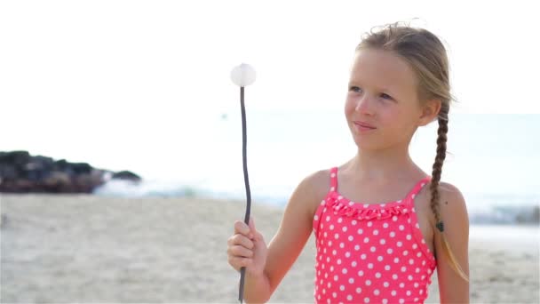Rozkošná holčička na pláži mají spoustu zábavy. Zpomalený pohyb — Stock video