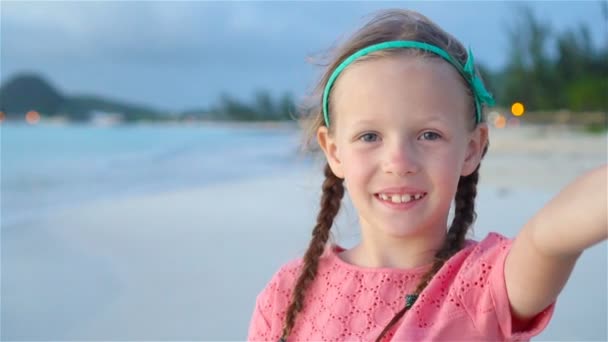 Urocza dziewczynka co selfie na tropikalnej plaży biały. Zwolnionym tempie — Wideo stockowe