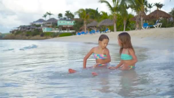 Adorables niñas relajándose en la playa jugando en aguas poco profundas — Vídeo de stock