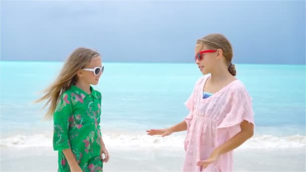 Kleine Mädchen amüsieren sich am tropischen Strand beim gemeinsamen Spielen. Zeitlupe — Stockvideo