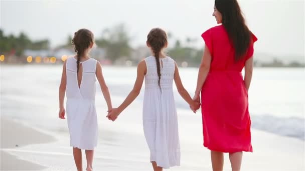 Maman et les enfants marchent au coucher du soleil. Famille de trois personnes marchant sur la plage de sable blanc — Video