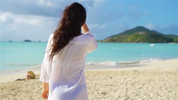 Jovem mulher bonita se divertindo na costa tropical. Menina feliz andando na praia tropical areia branca. LOW MOTION — Vídeo de Stock