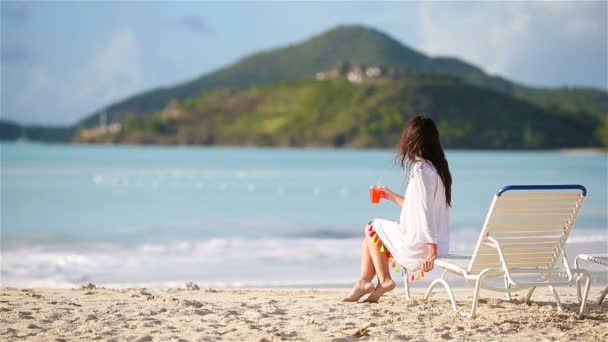 Молодая женщина с вкусным коктейлем на белом пляже — стоковое видео