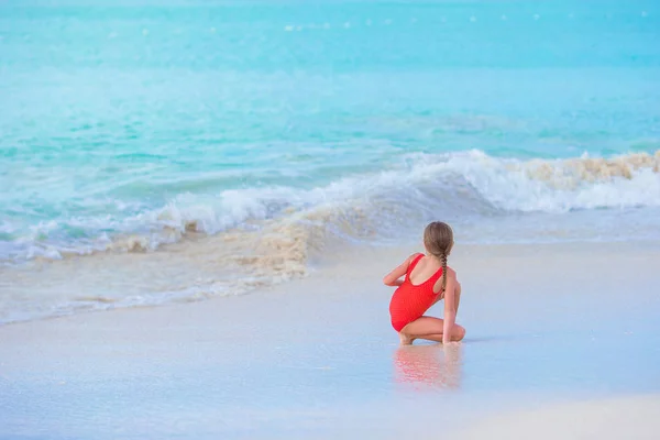 Adorable niña en la playa en aguas poco profundas — Foto de Stock