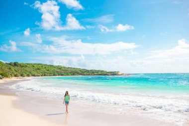 Genç ve güzel bir kadın beyaz kumsalda.