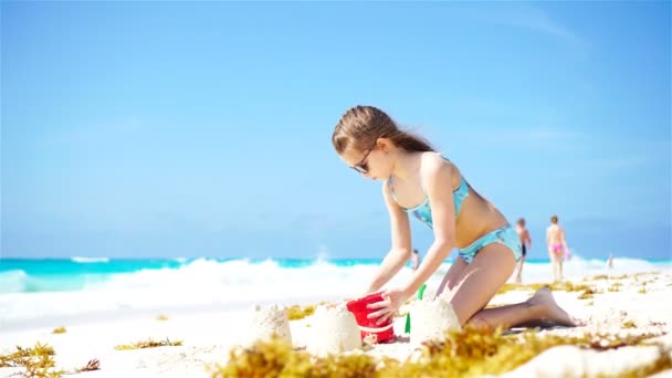 Adorável menina brincando com brinquedos e fazendo castelo de areia em férias na praia — Vídeo de Stock