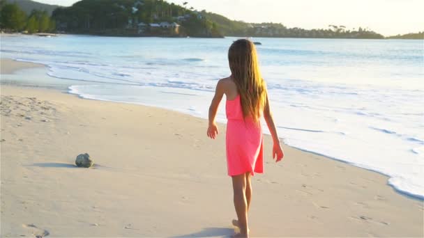 Adorável menina feliz se divertindo na praia branca ao pôr do sol. SLOW MOTION VIDEO — Vídeo de Stock