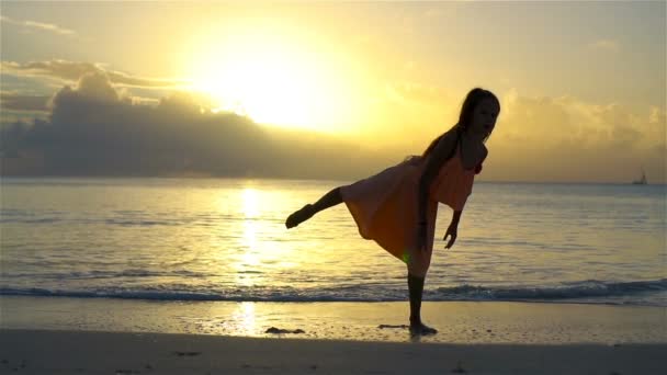 Entzückend glückliches kleines Mädchen, das Spaß am weißen Strand hat. Zeitlupenvideo — Stockvideo