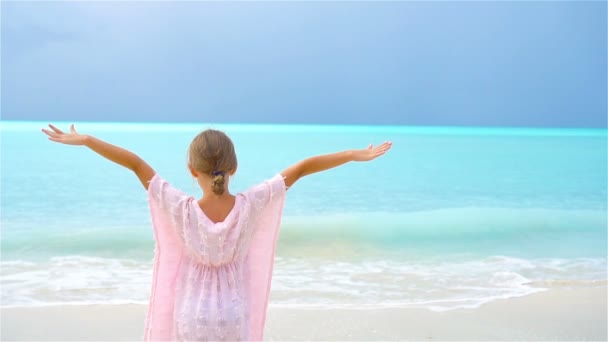 Αξιολάτρευτο ευτυχισμένη μικρό κορίτσι έχει τη διασκέδαση στην παραλία με λευκή. Βίντεο αργής κίνησης — Αρχείο Βίντεο